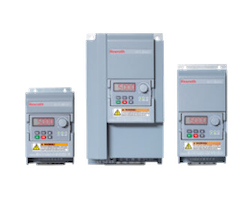 Three gray industrial variable frequency drives (VFDs) of different sizes arranged in a row, with digital displays and control panels facing forward.