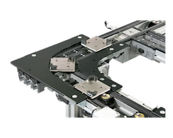 Close-up of a metal linear guide rail and carriage mounted on a steel framework, with multiple fasteners and brackets.
